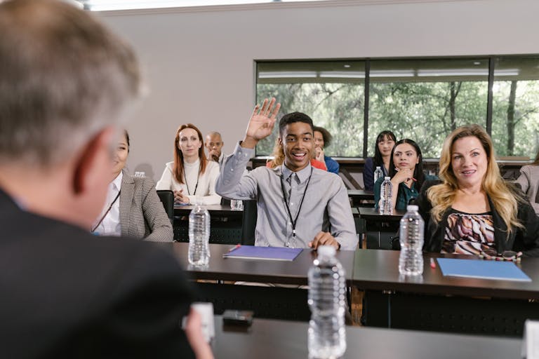 A Young Man Raising his Hand at a Business Conference