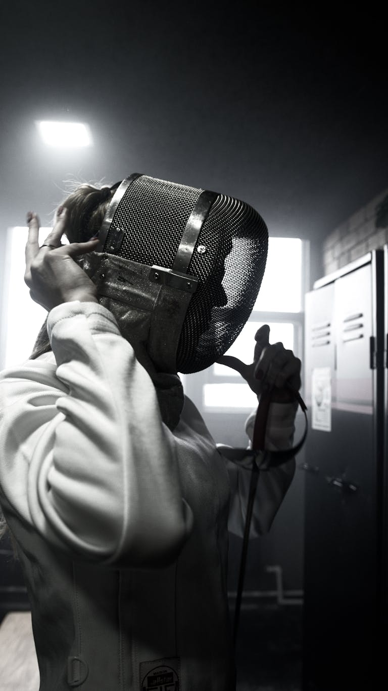 Person in White Coat Holding Black Leather Bag